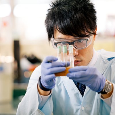 Jack Wang studies three test tubes in a holder in a laboratory